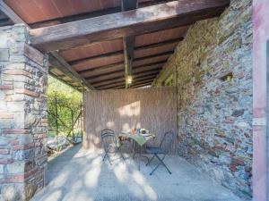 - un patio aux murs de pierre avec une table et des chaises dans l'établissement Apartment Le Fornaci-1 by Interhome, à San Quirico di Moriano