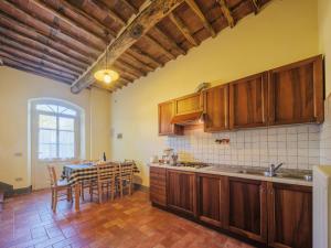 San Quirico di MorianoにあるApartment Le Fornaci-6 by Interhomeのキッチン(木製キャビネット、テーブル、椅子付)