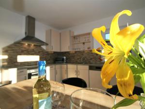 un fiore giallo su un tavolo con una bottiglia di vino di Apartment Hannah Lena by Interhome a Wiesing