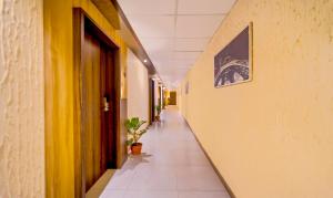 a hallway with yellow walls and a plant in it at Treebo Trend Golden Swan Airport Free Pick & Drop in Chennai