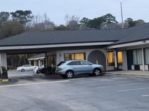 a car parked in a parking lot in front of a building at Studio 6 Suites Hinesville, GA in Hinesville