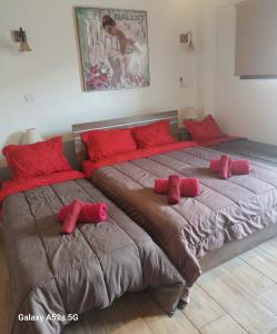 a bedroom with two beds with red pillows at Love Holiday Suite 1 in Tris Elies