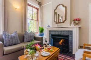 a living room with a couch and a fireplace at Bonne Esperance Boutique Guest House in Stellenbosch