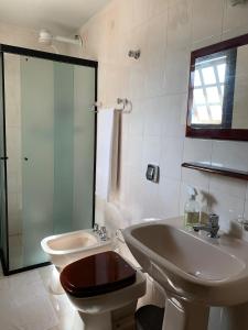 een badkamer met een wastafel, een toilet en een douche bij apartamento águas de lindoia itaigara in Águas de Lindóia