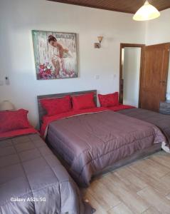 two beds with red pillows in a bedroom at Love Holiday Suite 2 in Tris Elies