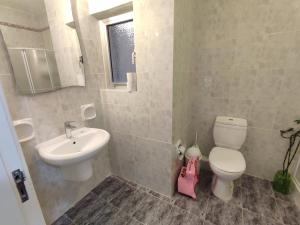 uma casa de banho com um WC branco e um lavatório. em Dolphin Court 3-Bedroom Sea View Apartment in Marsaskala, Malta em Marsaskala