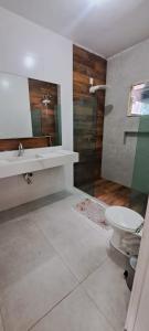 a bathroom with a sink and a toilet and a shower at Casa com piscina e muita tranquilidade in Rio de Janeiro