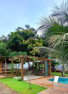 a garden with a wooden pergola and a swimming pool at Casa com piscina e muita tranquilidade in Rio de Janeiro