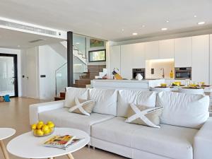 a living room with a white couch and a kitchen at Villa Bellavista in Cala Blava
