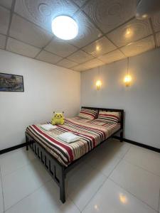 un dormitorio con una cama con un animal de peluche en LSN Mansion, en Ban Na Song