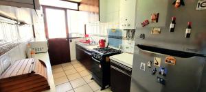 eine kleine Küche mit einem Herd und einem Kühlschrank in der Unterkunft Depto frente a la playa Av San Martin in Viña del Mar