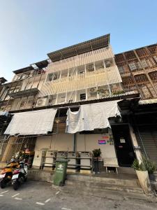 un edificio con balcón y una moto aparcada frente a él en LSN Mansion, en Ban Na Song