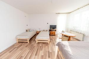 1 dormitorio con 2 camas y suelo de madera en Resia, en Krynica-Wieś