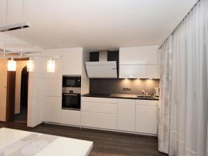 Una cocina con gabinetes blancos y electrodomésticos negros. en Apartment Kircher-2 by Interhome, en Aschau 32 fotos más