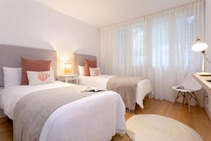 1 dormitorio con 2 camas con sábanas blancas y ventana en Genteel Home San Agustín, en Málaga