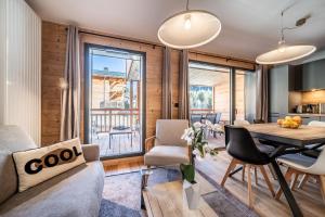 sala de estar con sofá, mesa y sillas en Apartment Clematis Les Gets- BY EMERALD STAY en Les Gets