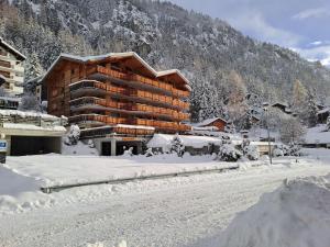 a large wooden building in the snow with a mountain at Apartment Les Mayens 3-2 by Interhome in Champex