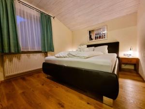 - une chambre avec un grand lit blanc et une fenêtre dans l'établissement Apartment Rätia II by Interhome, à Pfunds