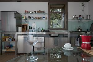 a glass of wine sitting on a glass table in a kitchen at Panama in Roccatederighi