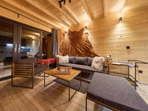 a living room with a couch and tables and a wall at Chalet Lux chalet by Interhome in Mladé Buky