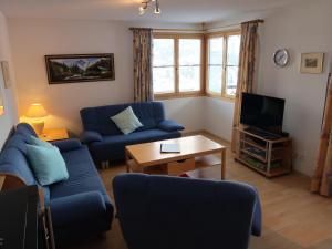 a living room with blue couches and a tv at Apartment Tga Stgirat Erdgeschoss by Interhome in Malmigiuer