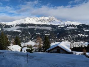 a snow covered mountain with a house in the foreground at Apartment Tga Stgirat Erdgeschoss by Interhome in Malmigiuer