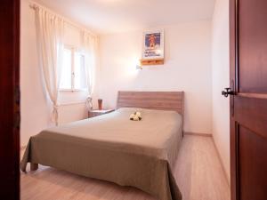 ein Schlafzimmer mit einem Bett mit einem Teddybär drauf in der Unterkunft Apartment Régina A20 by Interhome in Arveyes