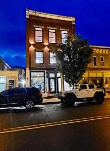 un camión y un coche estacionados frente a un edificio en Triple Brick on Main, en Wyalusing