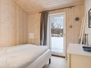 a bedroom with a bed and a window at Holiday Home Ferdine - 1-5km from the sea by Interhome in Knebel +11 photos