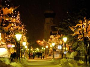Eine Gruppe von Leuten, die mit Weihnachtslichtern auf einer Straße spazieren in der Unterkunft Apartment Gampen by Interhome in Obergand