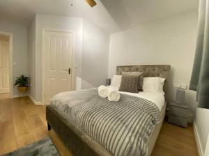 a bedroom with a bed with towels on it at Spacious 2 bed flat ideal for long stays in Purfleet