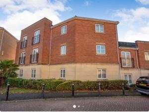 a brick building with a car parked in front of it at Spacious 2 bed flat ideal for long stays in Purfleet