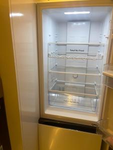 an empty refrigerator with its door open in a kitchen at Mercy 2 in Woolwich