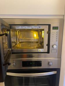 a microwave oven with its door open in a kitchen at Mercy 2 in Woolwich