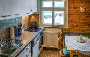 kuchnia ze zlewem i stołem z tableablish w obiekcie Beautiful Home In Wald Am Arlberg With Wi-fi w mieście Dalaas