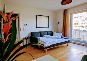 uma sala de estar com um sofá e uma planta em 65qm Altbaucharme mit zwei Balkonen em Karlsruhe