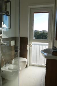 a bathroom with a toilet and a sink and a window at La perla del lago in Verbania