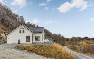 una casa blanca en una colina con un camino de tierra en Lovely Home In Sknevik With Wifi, en Skånevik