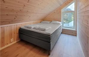 Cama en habitación de madera con ventana en Lovely Home In Sknevik With Wifi, en Skånevik
