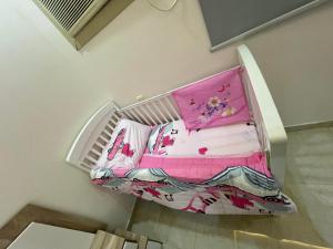 uma cama num quarto com lençóis cor-de-rosa em شقة كبيرة 3 غرف نوم وصالة Large apartment with 3 bedrooms and a living room em Taif