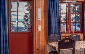 Habitación con mesa y puerta con vistas. en Cozy Home In Lillehammer With Sauna, en Nordseter