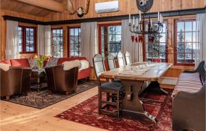 a dining room with a table and a couch at Cozy Home In Lillehammer With Sauna in Nordseter
