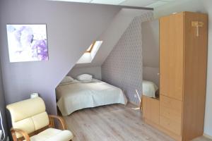 - une chambre mansardée avec un lit et une commode dans l'établissement Villa Katariina, à Pärnu