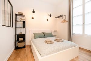 a white bedroom with a bed with two towels on it at Le Laurencin Sens - Le Keys - Cœur de ville in Sens