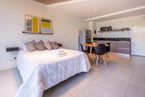 a bedroom with a bed and a table and a kitchen at NUEVO Loft triple a 5 minutos de Puerto Madero 1A in Buenos Aires