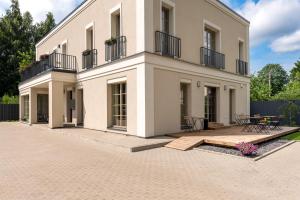 a large white building with a patio in front of it at Vilnius legends house APARTMENT I Best for families I Free parking in Vilnius