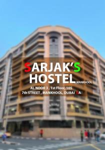 SARJAK'S HOSTEL MANKHOOL في دبي: عمارة سكنية كبيرة عليها لافتة