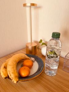 - une assiette de fruits sur une table avec une bouteille d'eau dans l'établissement Eishinan 栄進庵, à Fuji
