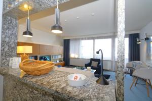 a living room with a kitchen and a living room with a couch at Haus Metropol 175 OB in Westerland (Sylt) +17 photos