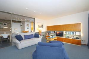a living room with a white couch and blue chairs at Haus Metropol 175 OB in Westerland (Sylt)